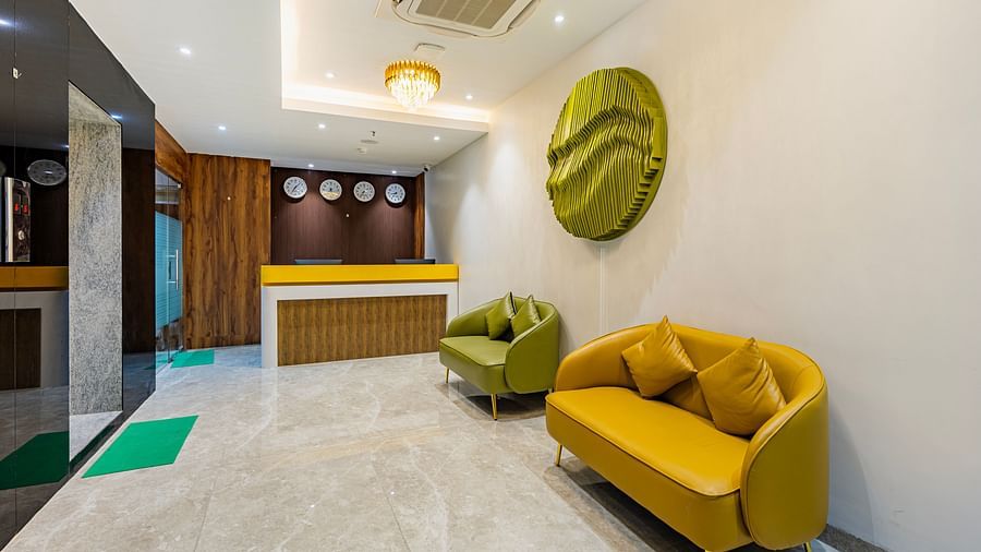 Lemonridge Hotels, KPHB | Lobby with green and yellow seating, contemporary wall decor, and a glimpse of the elevator.
